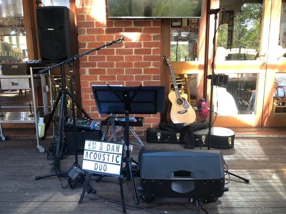 The duo’s acoustic guitar, speakers and lightbox sign set up on a pub verandah